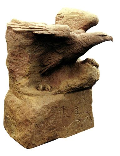 Steinskulptur "Die Erkenntnis des Adlers". Ein Adler wächst aus einem Felsen und setzt gerade zum Flug an.